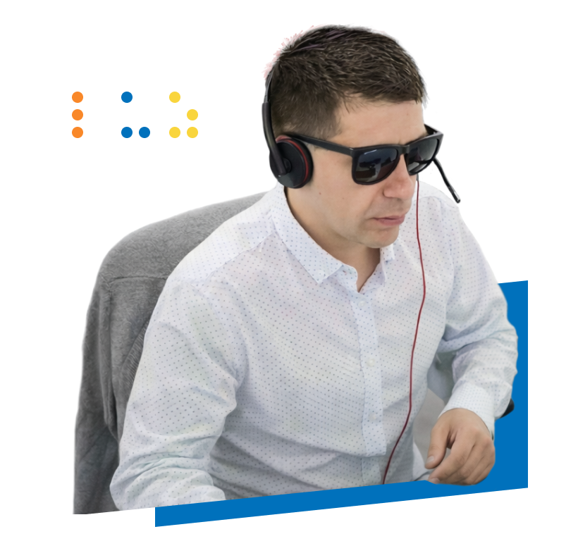 Hombre con gafas oscuras y audífonos con micrófono en un espacio de trabajo. Imagen del programa de inclusión laboral de Fundación Luz.